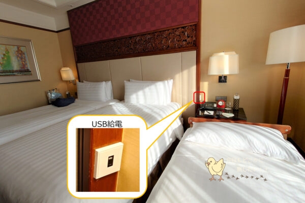 シャングリラ バンコクのデラックスリバービュールームのベッド周辺のUSB給電ポート